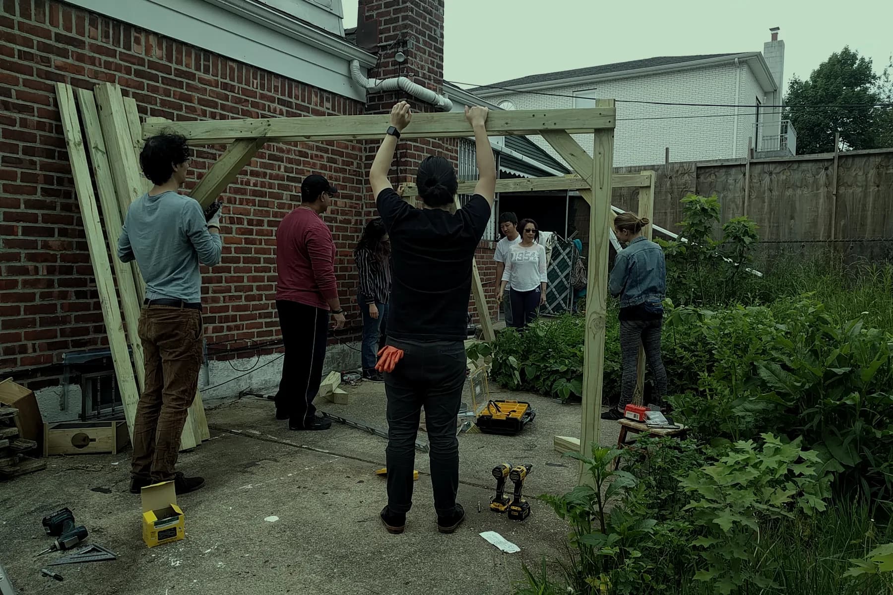A group raising a timber trellis frame